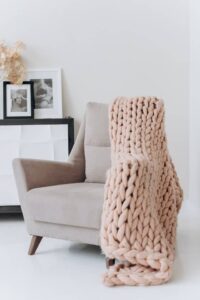 Fauteuil confortable avec un plaid, symbole de détente et d’apaisement