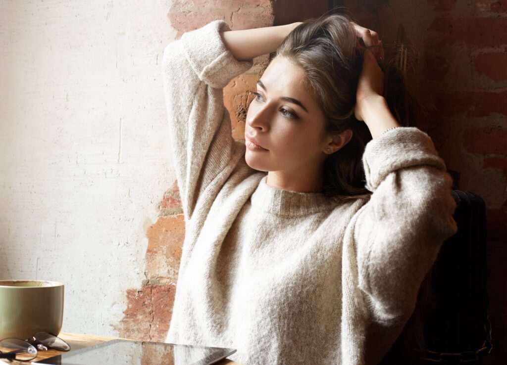 Femme pensive et fatiguée illustrant les liens entre stress, charge mentale et douleur chronique.